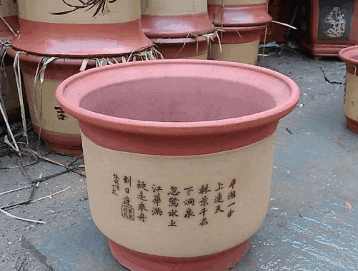 A ceramic planter with Chinese calligraphy, surrounded by other similar planters